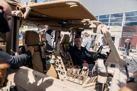 A person sitting in a military vehicle outdoors